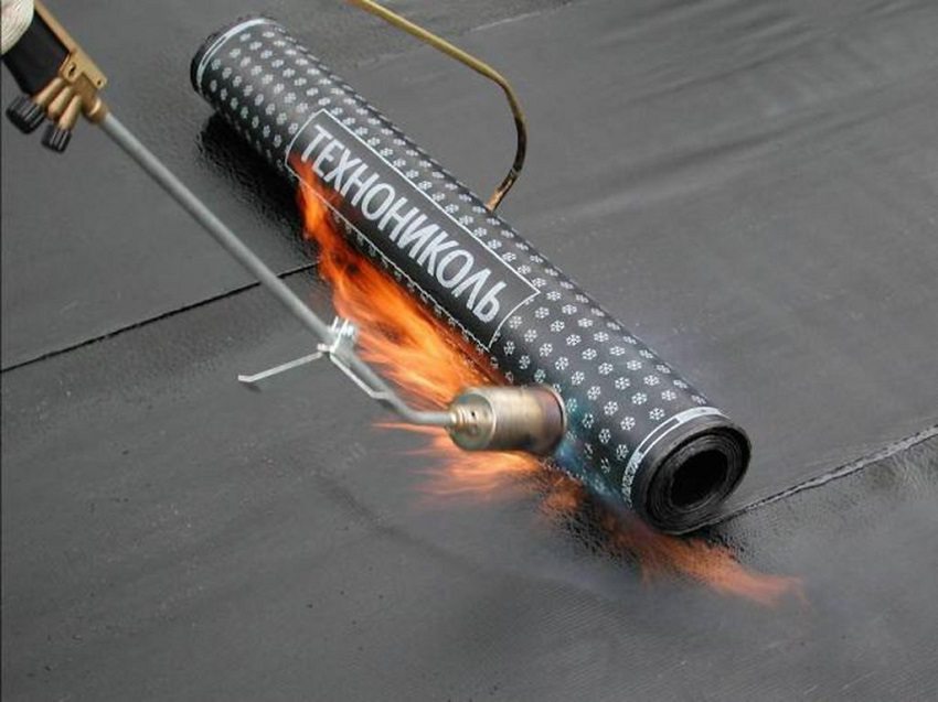 En gassbrenner brukes til å feste bitumenrullfilmen på overflaten.