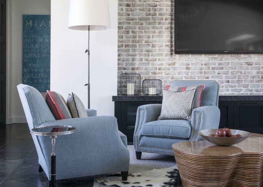 The TV screen stands out effectively against the background of light decorative bricks