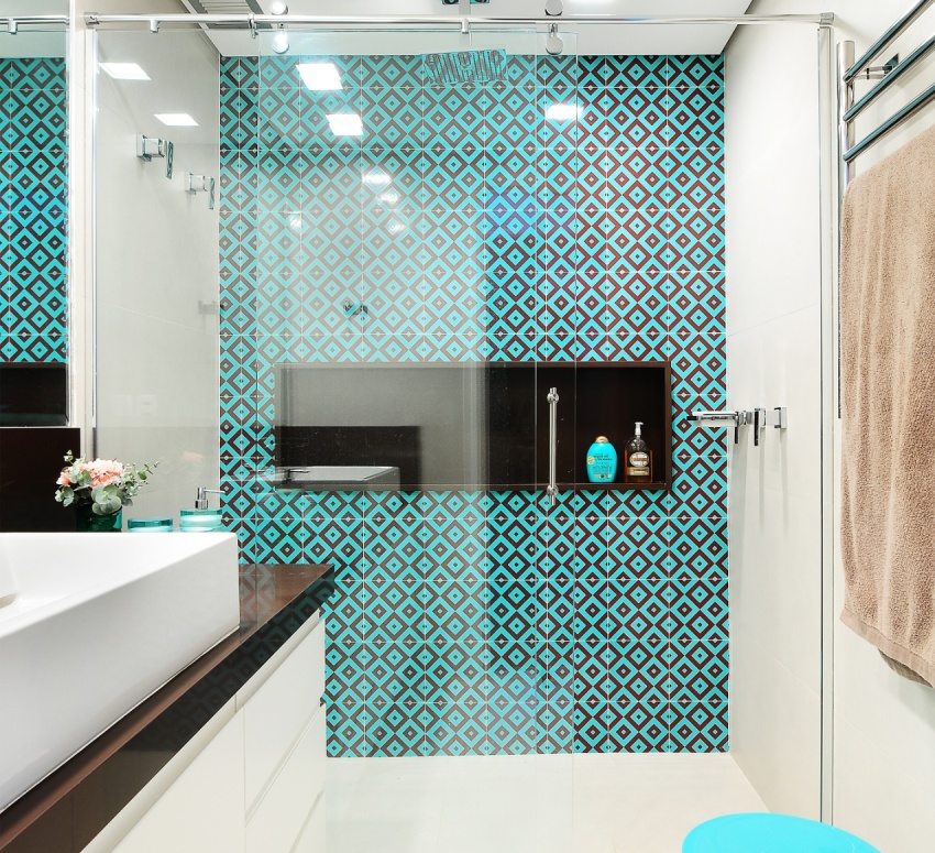 The shower area is tiled with bright turquoise tiles