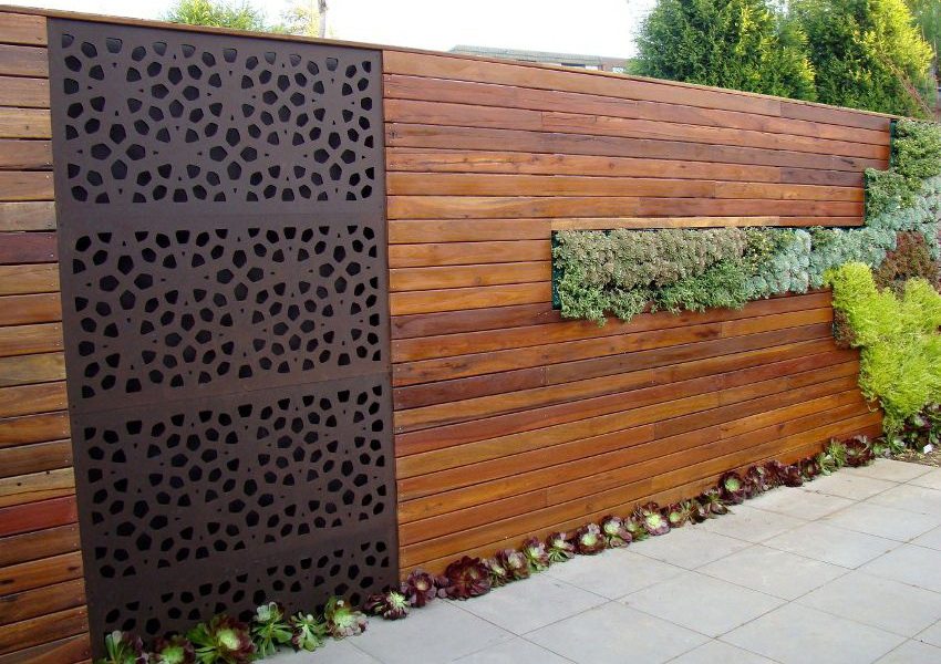 Modern design of the fence using different materials and landscaping
