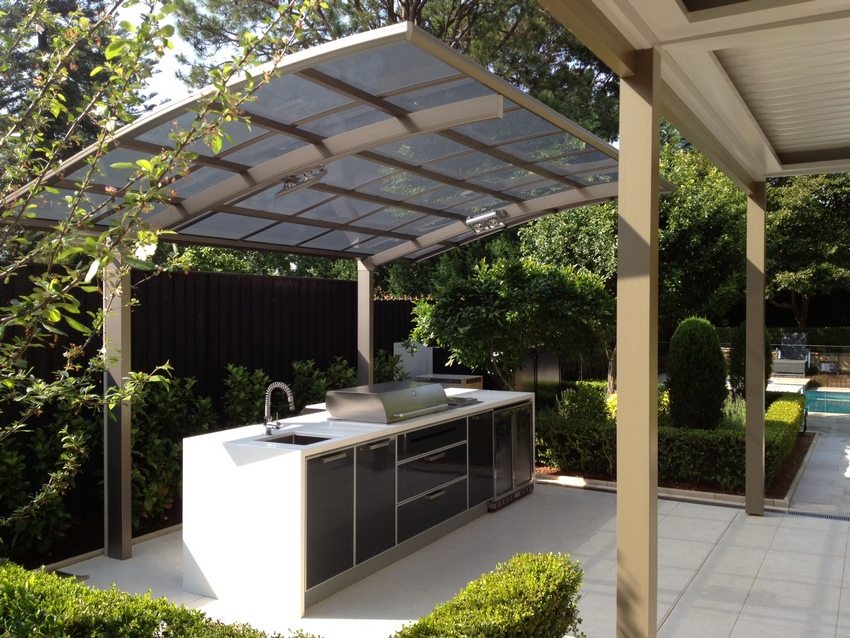 There is a kitchen under a canopy in the courtyard of a private house
