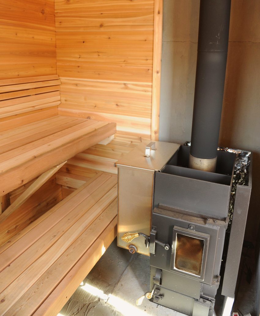 The water tank is suspended from the outside of the sauna stove