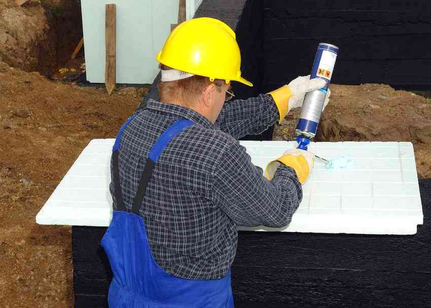 Applying glue to polystyrene foam plates, which is an effective insulation