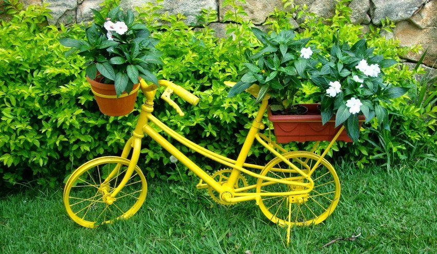 En gammel sykkel malt i en lys farge er et flott alternativ for å arrangere en blomsterhage