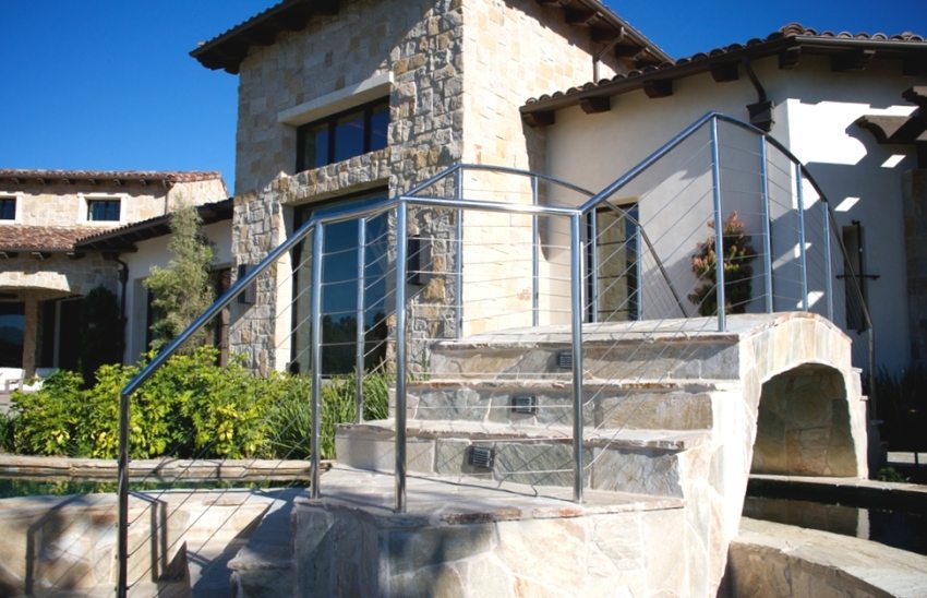 A stone bridge in the courtyard of a private house is decorated with stainless steel railings