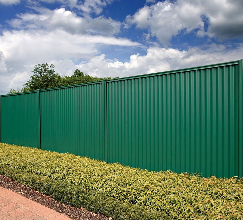 Simple solid corrugated fence around the territory of a private house