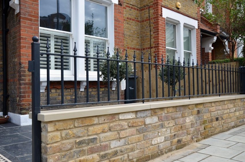 An example of a combination of brick and metal in the construction of a fence