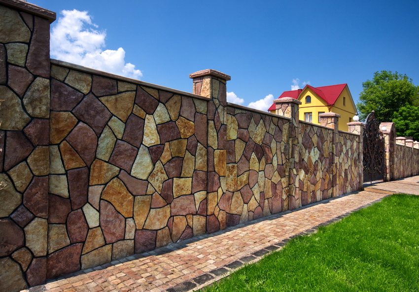 An interesting example of finishing a concrete fence under a natural stone