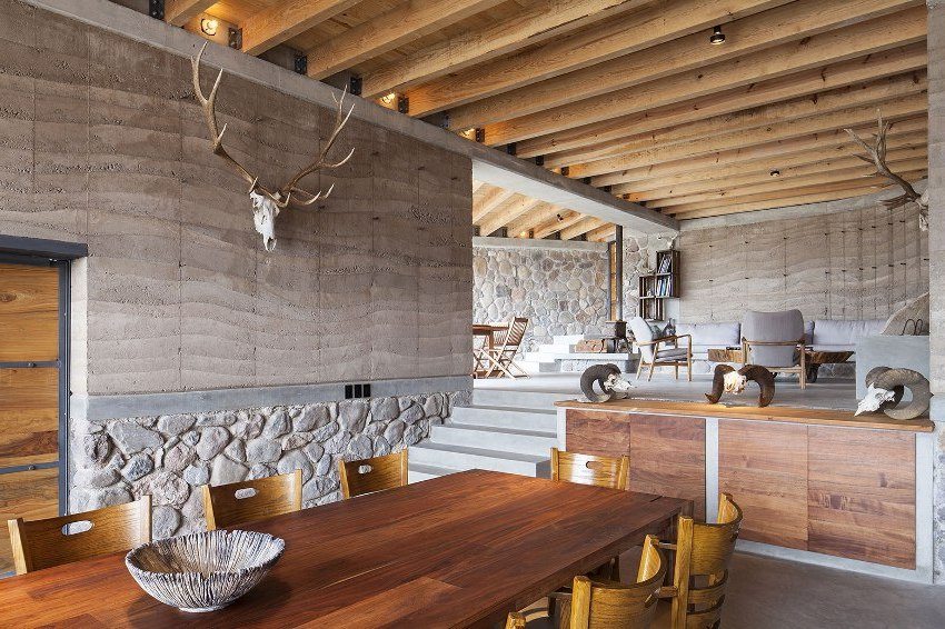 Stylish interior made of stone, concrete and wood, complemented by sculptures of trophy animals