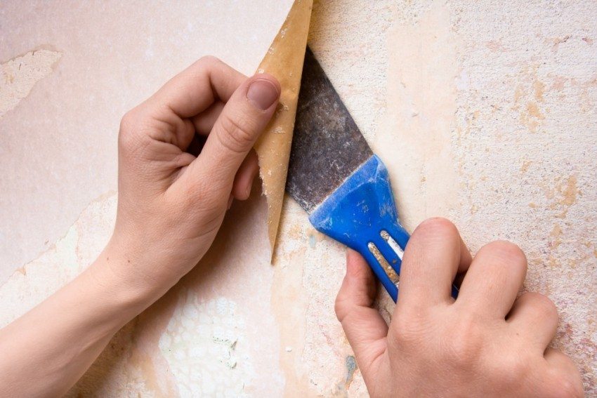 Removing the old coating from the wall with a spatula