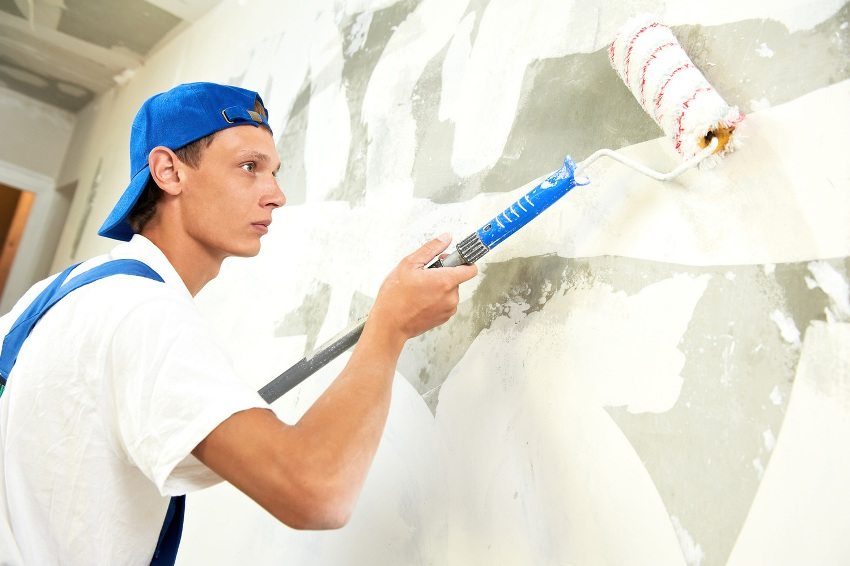 Priming walls using a long-handled paint roller