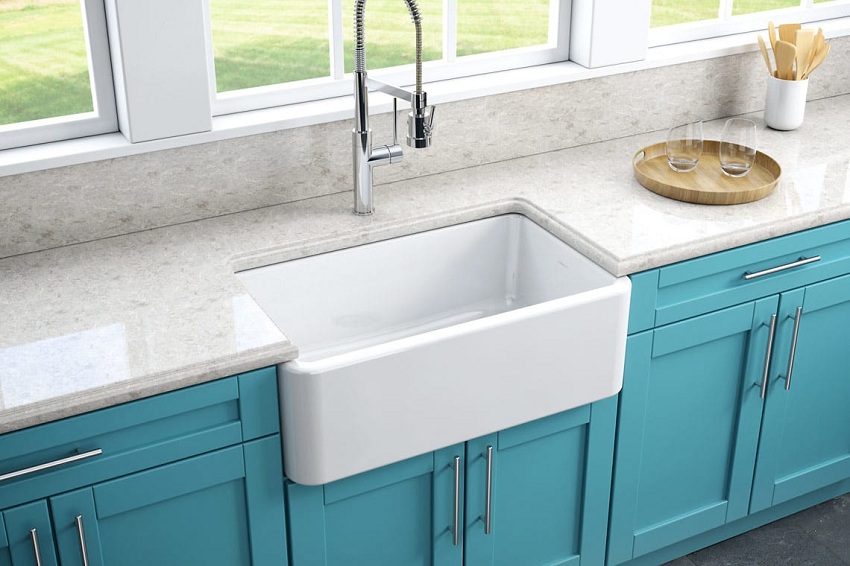 Kitchen sink made of traditional white ceramics harmonizes perfectly with the blue fronts