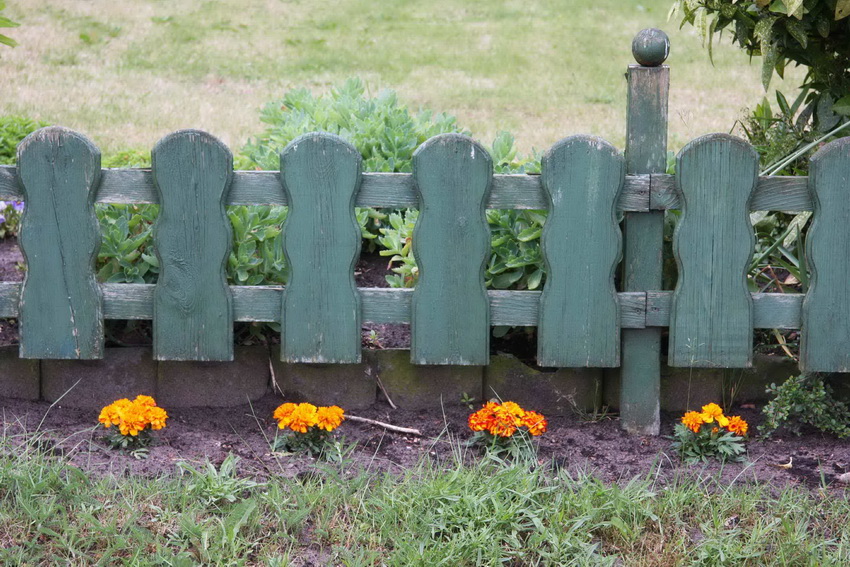 Decorative fence made of wood used for fencing flower beds looks quite elegant
