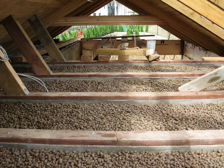 Expanded clay for insulation is poured between the logs and then all other work is carried out