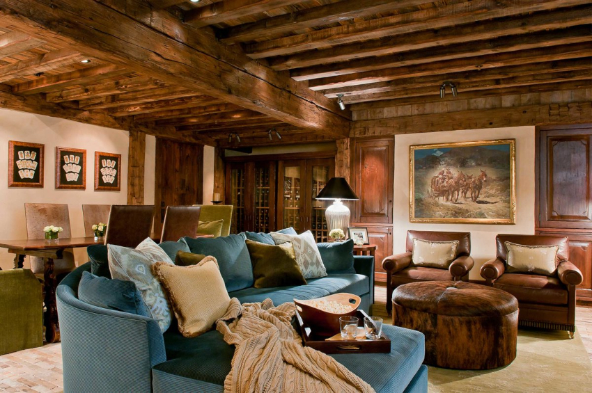 Kamin i strop s drvenim gredama glavne su značajke dnevne sobe u stilu zemlje.