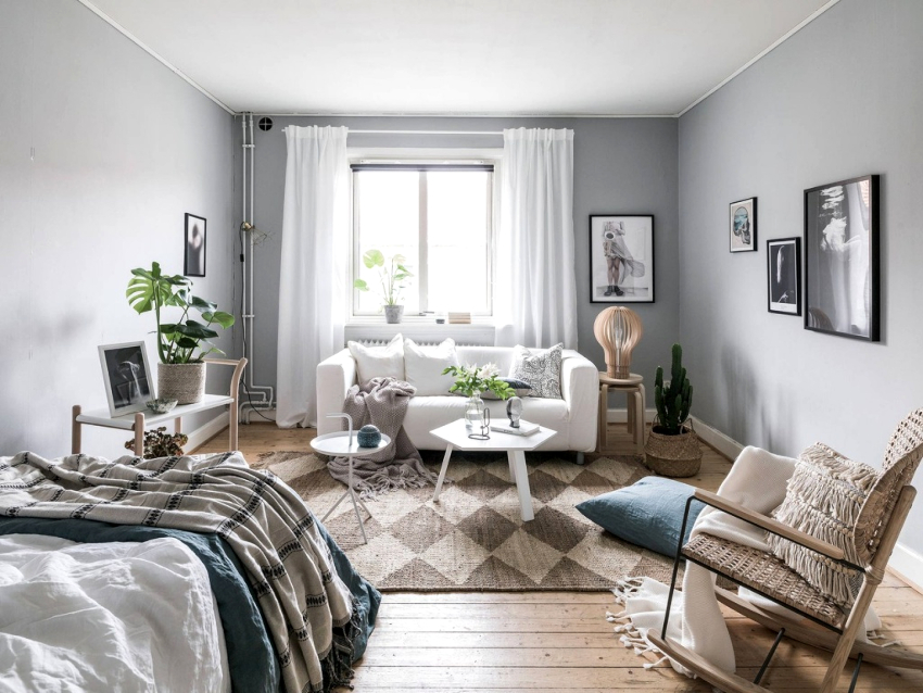 Dormitorul-living în stil scandinav este decorat într-o paletă ușoară