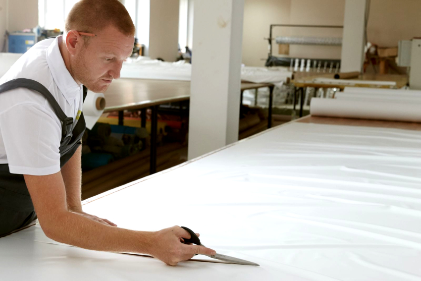 Using the obtained dimensions of the room, the fabric is cut in the workshop