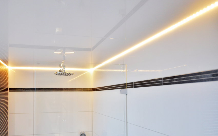 The LED strip is mounted in niches between the stretch fabric and the ceiling plinth