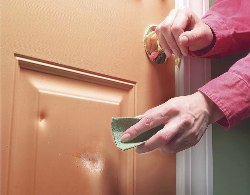 Dents on the surface of a veneer door are sealed with a special wax
